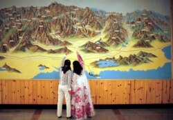 FILE - People look at a map on a wall in Mount Kumgang resort, Sept. 1, 2011.