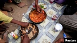 Members of the Ruzaiq family eat a meal outside their hut, next to a garbage dump where they collect recyclables and food near the Red Sea port city of Hodeidah, Yemen, Jan. 9, 2018.