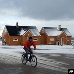 A man cycles through the Norwegian Arctic settlement of Ny Alesund as the first snows of winter arrive (File)