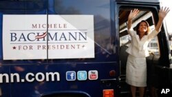 Republican presidential candidate Rep. Michele Bachmann, R-Minn., waves from the steps of her campaign bus after being named the winner of the Iowa Republican Party's Straw Poll, Saturday, Aug. 13, 2011, in Ames, Iowa. (AP Photo/Charlie Neibergall)