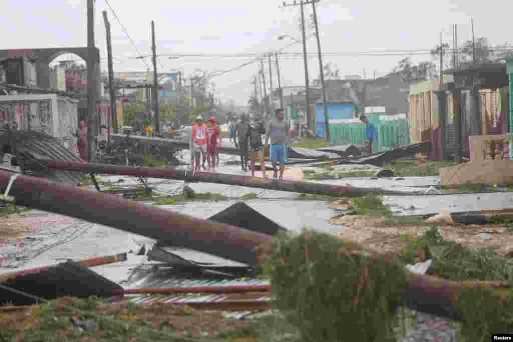 People walk on a damaged street after the passage of Hurricane Irma in Caibarien, Cuba, Sept. 9, 2017.