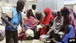 ARCHIVES - Des femmes et des enfants du sud de la Somalie font la queue pour recevoir des aliments cuits distribués par le Programme alimentaire mondial (PAM) à Mogadiscio, en Somalie, le 20 août 2011.