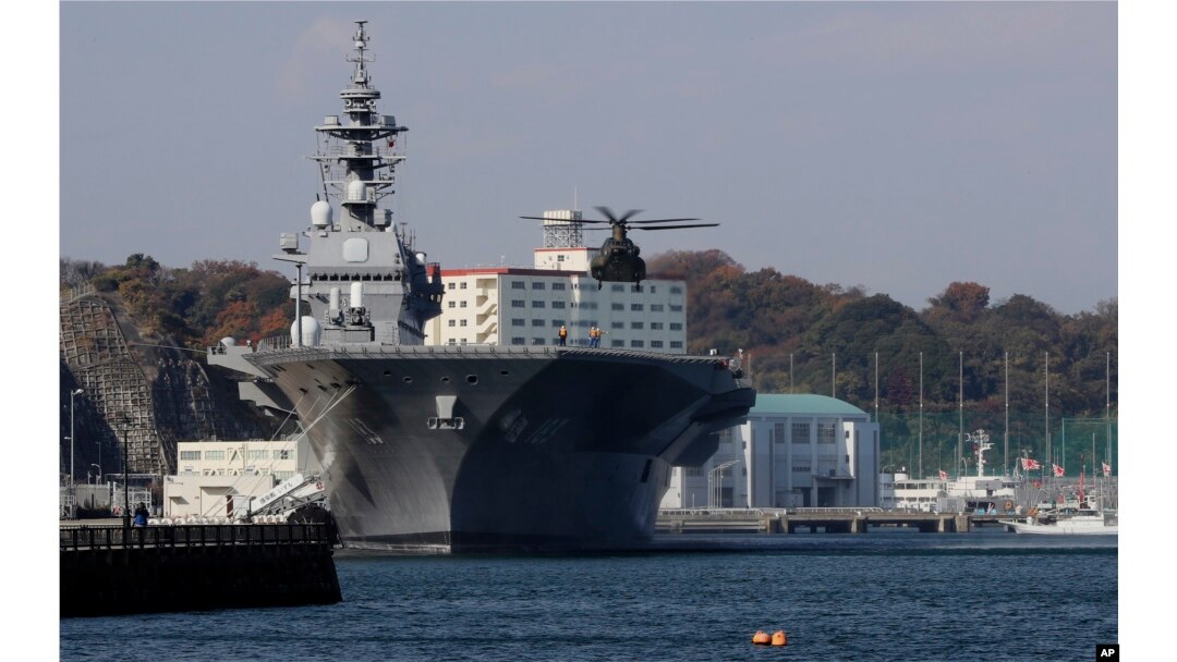 在日本横须贺,一架直升机准备降落在日本海上自卫队“出云”号直升机驱逐舰的飞行甲板上。(2016年12月6日)