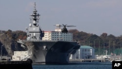 A helicopter of Japan Self-Defense Forces prepares to land on the flight deck of the helicopter destroyer Izumo of Japan's Maritime Self-Defense Force.