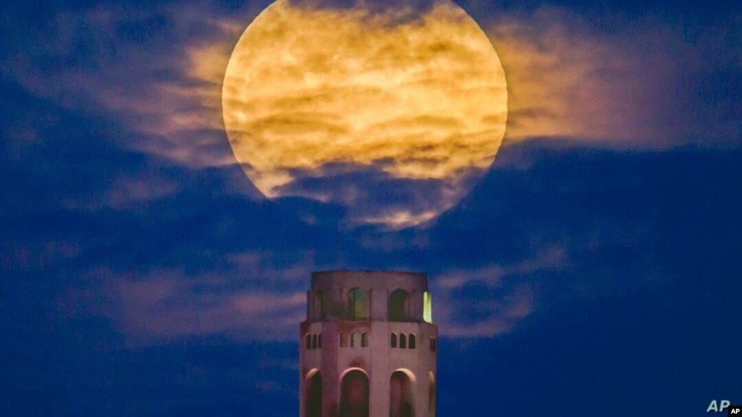 Una superluna rosa se eleva en el cielo nocturno sobre la Torre Coit en San Francisco, California, el 26 de abril de 2021.