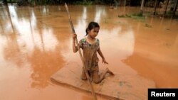 A girl uses a mattress as a raft during the flood after the Xe Pian Xe Namnoy hydropower dam collapsed in Attapeu province, Laos July 26, 2018.