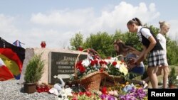 Para pengunjung berkumpul dekat monumen peringatan untuk para korban pesawat Malaysia Airlines MH17 dalam peringatan empat tahun kecelakaan itu dekat Desa Hrabove (Grabovo) di Wilayah Donetsk , Ukraina, 17 Juli 2018. 