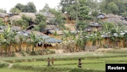 Children stand near camps housing Rohingya refugees on hills in Kutupalong, Bangladesh, May 31, 2015. 