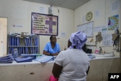 FILE—A nurse consults a relative to a male patient admitted to men's ward at Karanda Mission Hospital in Mount Darwin on March 2, 2024.