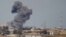File - A plume of smoke rises above a building after an airstrike by the U.S.-led coalition battling the Islamic State group, in Tikrit, Iraq, March 2015. 