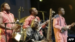 FILE - Toumani Diabaté (C) of Mali plays on his kora, an African harp, in Budapest, Aug. 11, 2006.