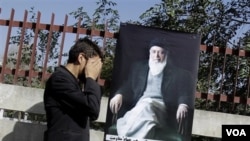 Seorang pejalan kaki memberikan doa ketika melewati poster almarhum mantan presiden Burhanuddin Rabbani yang terbunuh (foto:dok).