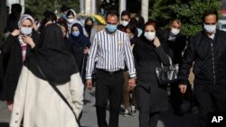 People wearing protective face masks to help prevent the spread of the coronavirus walk in downtown Tehran, Iran, Monday, April 5, 2021. Iran shattered its daily record for new coronavirus infections Wednesday for the second consecutive day, with…