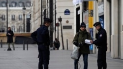 警察在巴黎香榭丽舍大街拦住一名滑滑板的男士。(2020年3月17日)