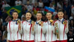 El equipo de China posa para una fotografía después de ganar la medalla de oro en la prueba general grupal de gimnasia rítmica en La Chapelle Arena durante los Juegos Olímpicos de Verano de 2024, el sábado 10 de agosto de 2024, en París, Francia.