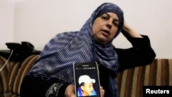 مادر محمد ابوخضیر تصویر پسرش را در تلفن همراه خود در منزلش واقع در یک منطقه عرب نشین حومه اورشلیم نشان می دهد - ۲ ژوئیه ۲۰۱۴