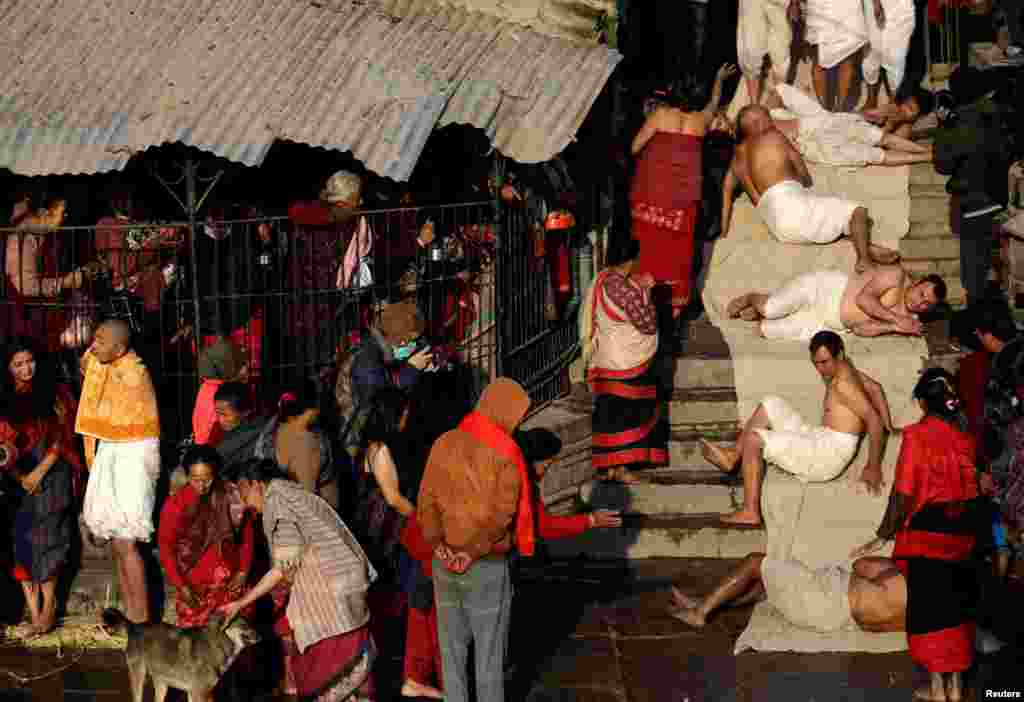 Devotees offer prayers by rolling on the ground during the first day of the month-long Swasthani Brata Katha festival in Bhaktapur, Nepal.