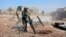 In this photo released by the Syrian official news agency SANA, Syrian army soldiers prepare to launch a mortar towards insurgents in the village of Kfar Nabuda, in the countryside of Syria's Hama province, May 11, 2019.