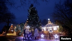 Para pengunjung memasuki rumah pribadi yang dihiasi dengan lampu Natal di Desa Chotovice dekat Kota Litomysl, Republik Ceko, 18 Desember 2018.