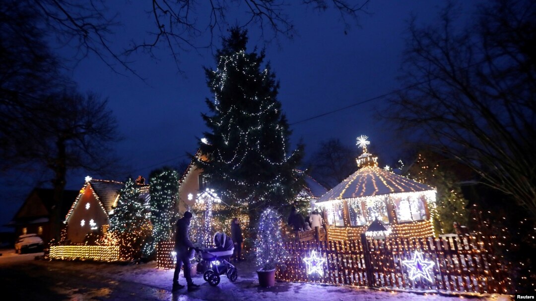 Para pengunjung memasuki rumah pribadi yang dihiasi dengan lampu Natal di Desa Chotovice dekat Kota Litomysl, Republik Ceko, 18 Desember 2018.
