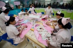 FILE - Infants undergo a daily medical examination at a maternal and child health care hospital in Taiyuan, Shanxi province, Dec. 3, 2012. Analysts say China's new two-child policy could spur economy.