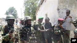 Somali president Sheik Sharif Sheik Ahmed (2nd L) comes to see where police displayed the bodies of four al-Shabab fighters killed during fighting in Mogadishu, Mar 22 2011