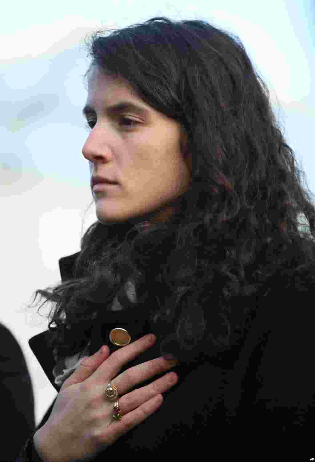 Tatiana Schlossberg, granddaughter of President John F. Kennedy, stands still as the U.S. national anthem is played during a short ceremony at the JFK memorial, Runnymede, England, Nov. 22, 2013. 