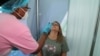 A healthcare worker collects a swab from Bronwen Cook for a PCR test against the coronavirus disease (COVID-19) before traveling to London, at O.R. Tambo International Airport in Johannesburg, South Africa, Nov. 26, 2021. 