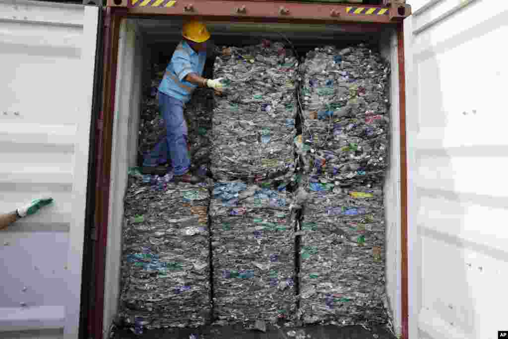 A worker stands inside a container full of plastic waste at Tanjung Priok port in Jakarta, Indonesia. Indonesia is sending hundreds of containers of waste back to Western nations after finding they were contaminated with used plastic and hazardous materials.
