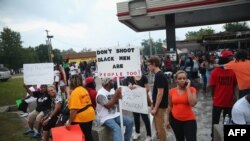 被警察打死的黑人青年家乡的民众在街头抗议。他们手里的标语牌上写着“不要枪杀黑人，黑人也是人”