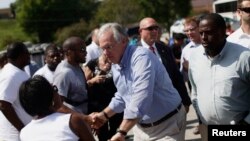 El gobernador de Missouri, Jay Nixon, saluda a manifestantes en Ferguson.