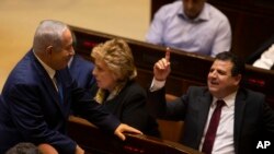 FILE - Israeli Prime Minister Benjamin Netanyahu speaks with Israeli Knesset member Ayman Odeh during a session in Jerusalem, Dec. 26, 2018. 