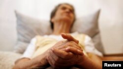 FILE - Alzheimer's disease patient Isidora Tomaz, 82, sits in an armchair in her house in Lisbon, Portugal, Sept.15, 2009. 