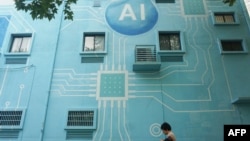 A woman walks past a building whose exterior wall was painted to look like a circuit board with an AI logo in Hangzhou, in China's eastern Zhejiang province, Oct. 30, 2024. 