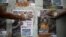 Opposition supporters use their hands to glue posters of candidates for the National Assembly of the Venezuelan coalition from opposition parties (MUD) in Caracas, Dec. 2, 2015.
