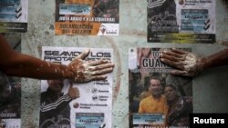 Votantes de oposición pegan pósters de sus candidatos a la Asamblea Nacional en Caracas. Las elecciones legislativas se realizarán el domingo 6 de diciembre.