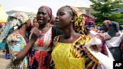 FILE - In this photo released by the Nigeria State House, Family members react as they embrace a relative, one of the released kidnapped schoolgirls, in Abuja, Nigeria.