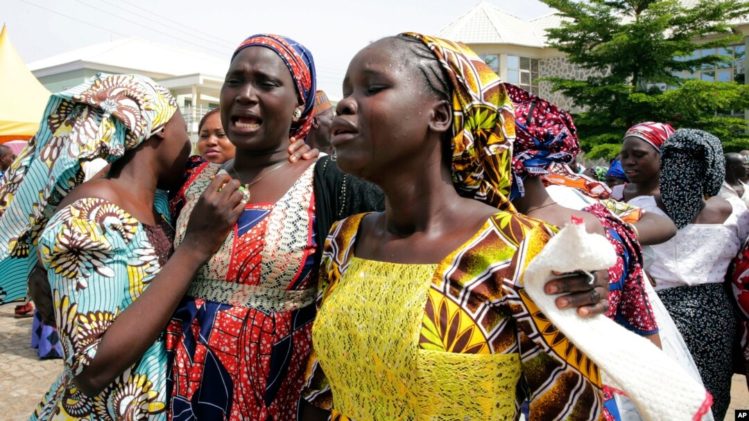 FILE - In this photo released by the Nigeria State House, Family members react as they embrace a relative, one of the released kidnapped schoolgirls, in Abuja, Nigeria.