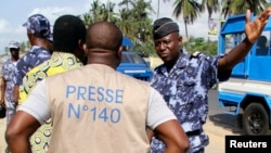 Un policier discute avec un journaliste lors d'un sit-in de protestation contre une nouvelle loi sur les médias à Lomé, au Togo, le 14 mars 2013.