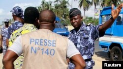 Un policier discute avec un journaliste lors d'un sit-in de protestation contre une nouvelle loi sur les médias à Lomé, au Togo, le 14 mars 2013.