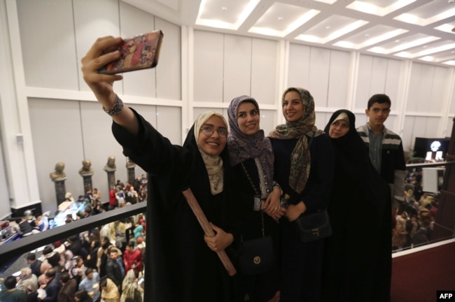 Theatre-goers take a selfie picture at the Espinas Hotel in the Iranian capital Tehran, before watching the musical production Les Miserables, performed in Persian by local artists, Dec. 3, 2018.