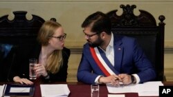 El presidente de Chile, Gabriel Boric, escucha a su asesora constitucional Beatriz Hevia, durante un acto político e institucional en Santiago de Chile, el 7 de noviembre de 2023.