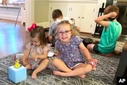 Brynn Schulte, 4, center, plays with her nanny's daughter Gracie Grubbs before getting an infusion of medication, which she must get every day for her genetic bleeding disorder, at home in Cincinnati, Ohio on August 3, 2023. (AP Photo/Laura Ungar)