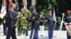 A member of an honor guard helps U.S. President Barack Obama (L) lay a wreath in honor of Memorial Day at the Tomb of the Unknowns in Arlington National Cemetery in Arlington, Virginia, May 28, 2012