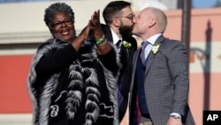 Aubrey Loots (R) and Danny Leclair, the first gay couple to be married aboard a float in the Tournament of Roses, kiss after being wed by the Rev. Alfreda Lanoix of the Unity Fellowship Church of Christ (L), aboard the AIDS Healthcare Foundation float in 