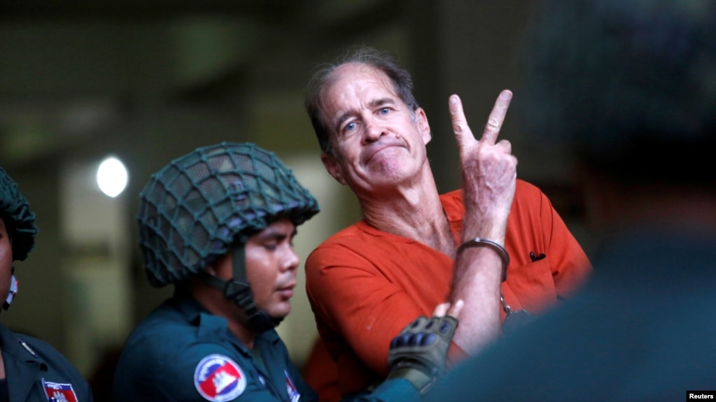 លោក James Ricketson អ្នកផលិតភាពយន្តឯកសារជនជាតិអូស្ត្រាលី បានលើកដៃ នៅពេលដែលលោកត្រូវបាននាំខ្លួនមកដល់សាលាដំបូងរាជធានីភ្នំពេញ កាលពីថ្ងៃទី១៦ ខែសីហា ឆ្នាំ២០១៨។