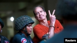 រូបឯកសារ៖ លោក​ James Ricketson អ្ន​កផលិត​ភាព​យន្ត​ឯកសារ​ជនជាតិ​អូស្ត្រាលី បានលើក​ដៃ​ នៅ​ពេល​ដែល​លោក​ត្រូវបាន​នាំ​ខ្លួន​មក​ដល់​សាលាដំបូង​រាជធានីភ្នំពេញ កាលពីថ្ងៃទី១៦ ខែសីហា ឆ្នាំ២០១៨។