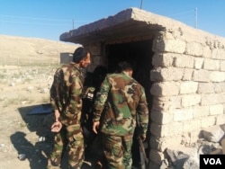 Peshmerga soldiers examine a tunnel build by Islamic State militants, one of the ways the group managed to hold villages for more than two years in Tarjala in the Kurdish region of northern Iraq, Oct. 29, 2016. (H. Murdock/VOA)
