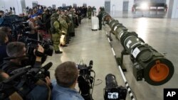 Foreign military attaches and journalists attend a briefing by the Russian Defense Ministry as the 9M729 land-based cruise missile, right, in Kubinka, Russia, Jan. 23, 2019. The Russian military rolled out its new missile and spelled out its specificatio