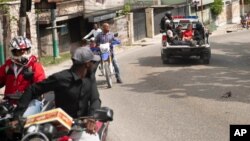 A police truck takes two suspects to the police station of Petion Ville in Port-au-Prince, Haiti, Thursday, July 8, 2021. Police Chief Leon Charles said the two are suspects in the assassination of Haitian President Jovenel Moïse.